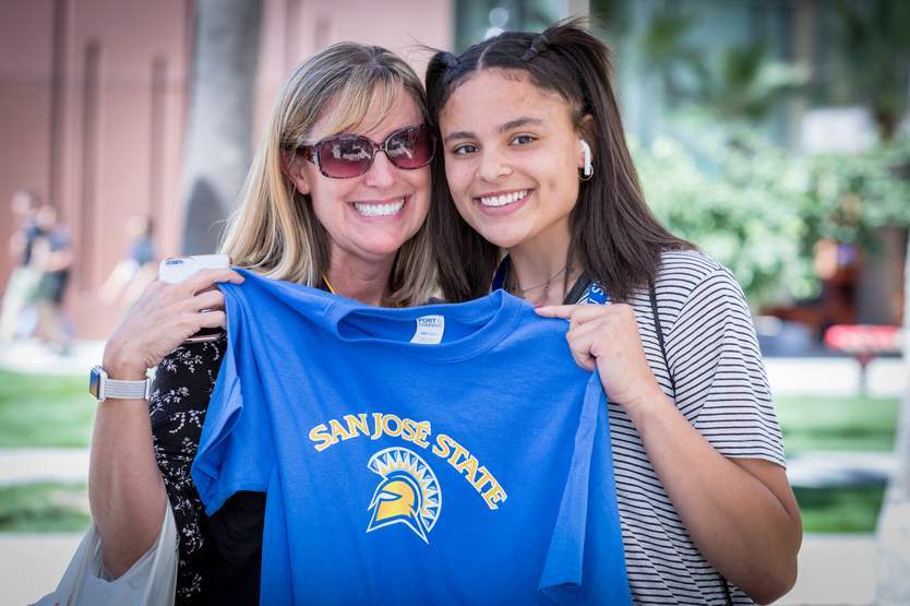 happy student holding SJSU Tshirt