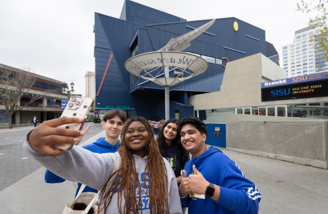 Students taking a self portrait with a mobile phone outside the Hammer Theatre Center.